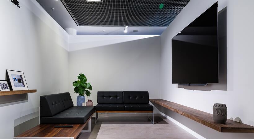 Sala de estar moderna com televisão LED afixada à parede.