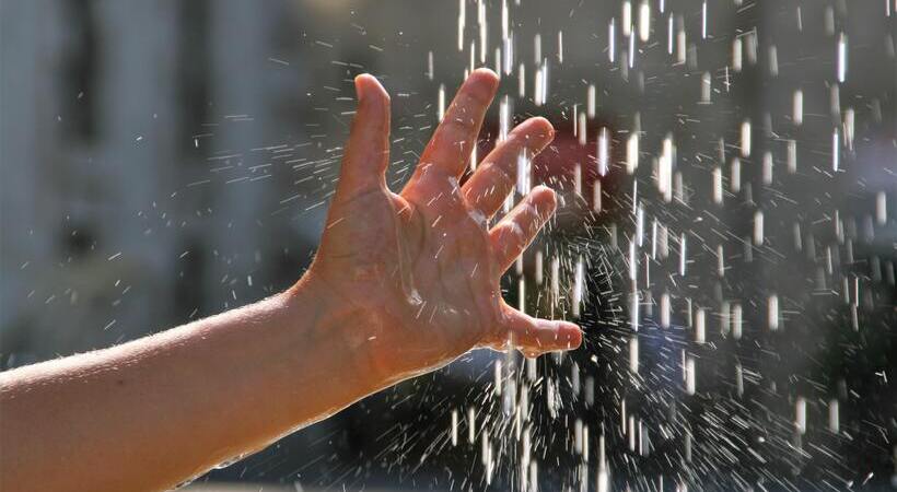 Criança com a mão em água corrente