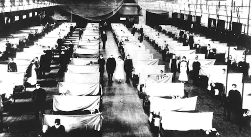 Foto em preto e branco de corpos em macas, em um galpão, durante a gripe espanhola.
