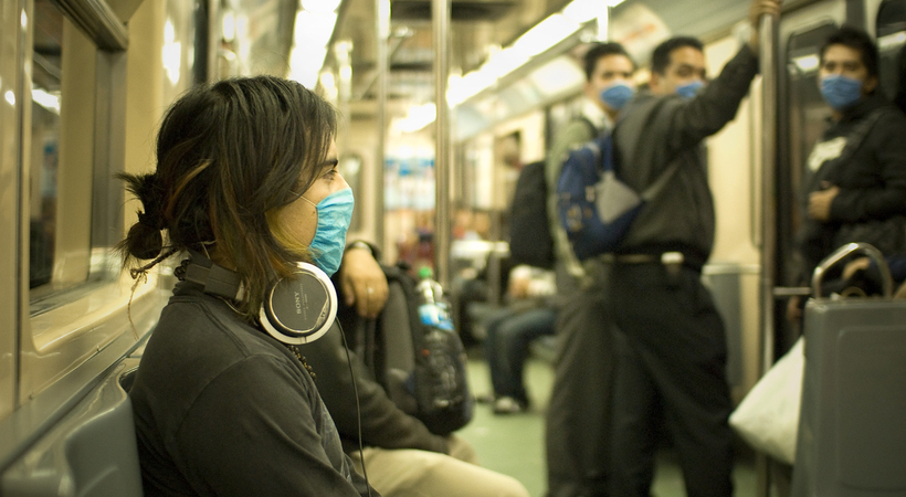 Pessoas usando máscara sobre o nariz e a boca durante surto de gripe suína em um país oriental.